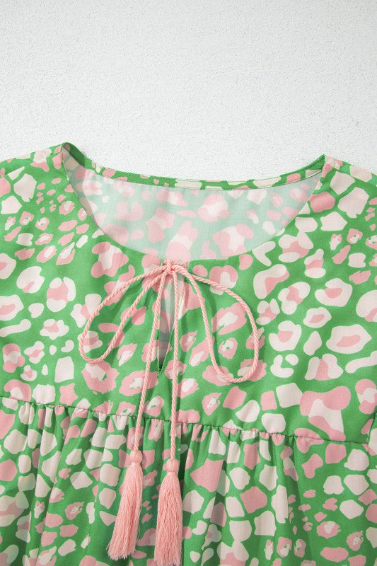 Green and pink patterned dress with a tie neckline on a white background