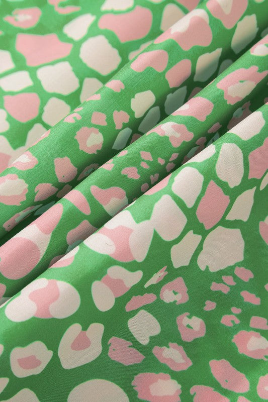 Fabric with pink and white abstract pattern on a green background
