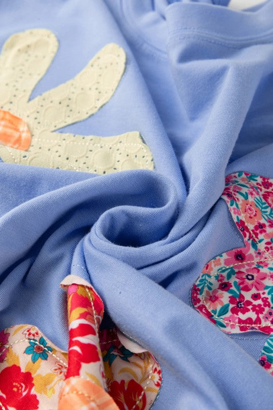 Close-up of blue fabric with colorful floral patches