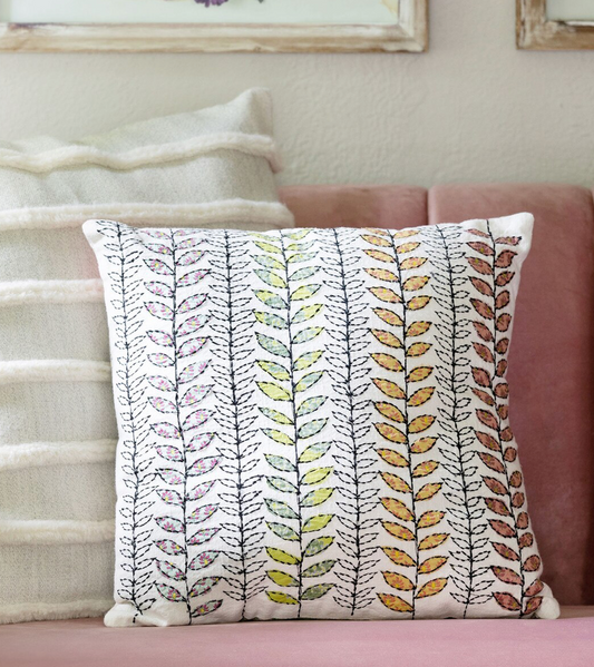 Decorative pillow with leaf pattern on a couch