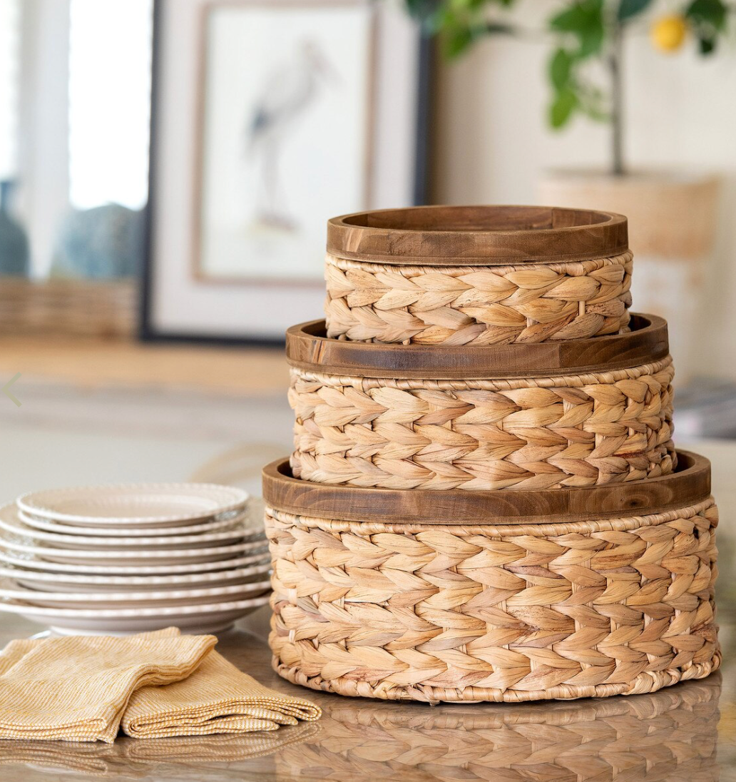 Stack of woven baskets on a table with a blurred indoor background