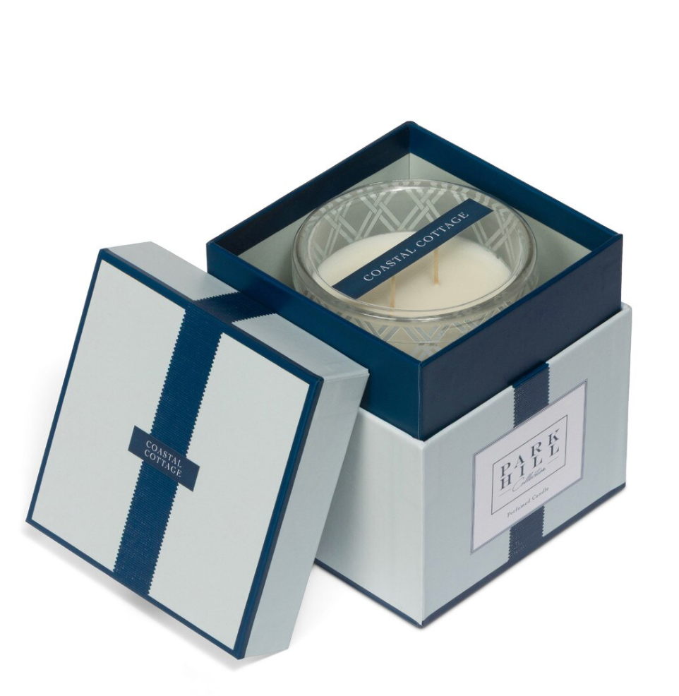 Candle in a decorative box with 'Coastal Cottage' branding on a white background