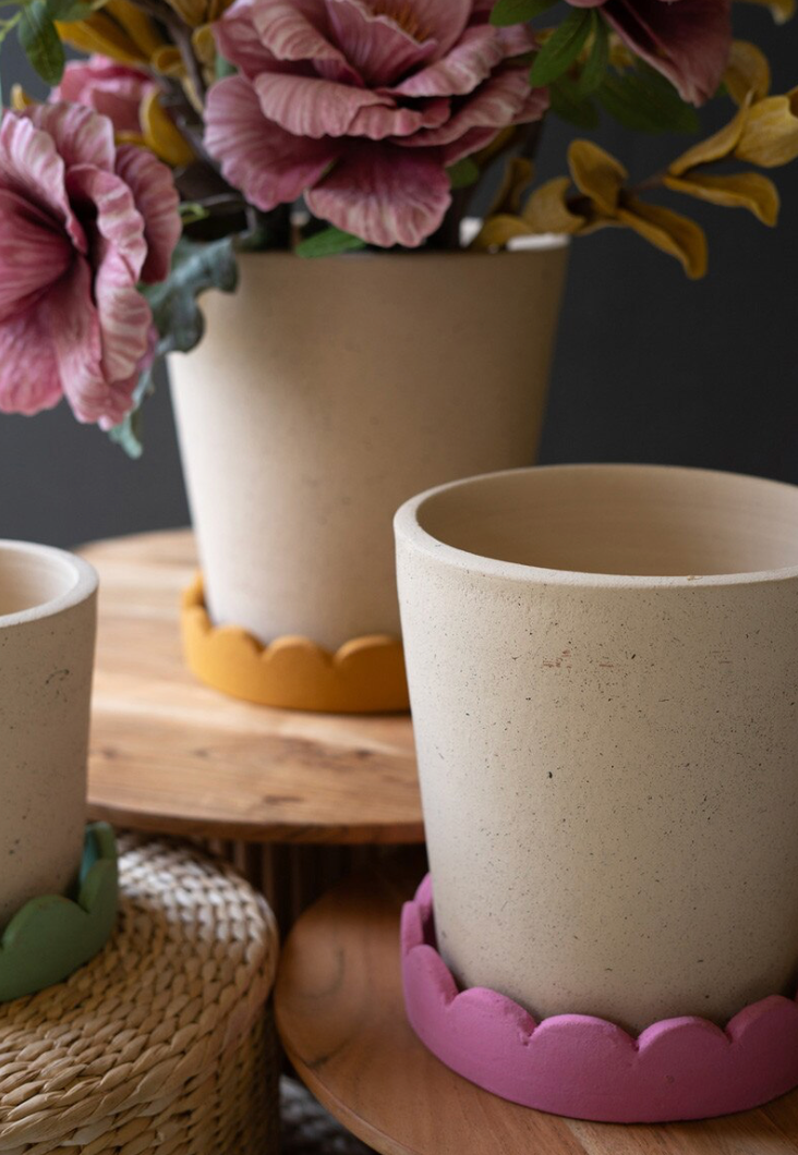 Ceramic pots with decorative bases on a wooden surface