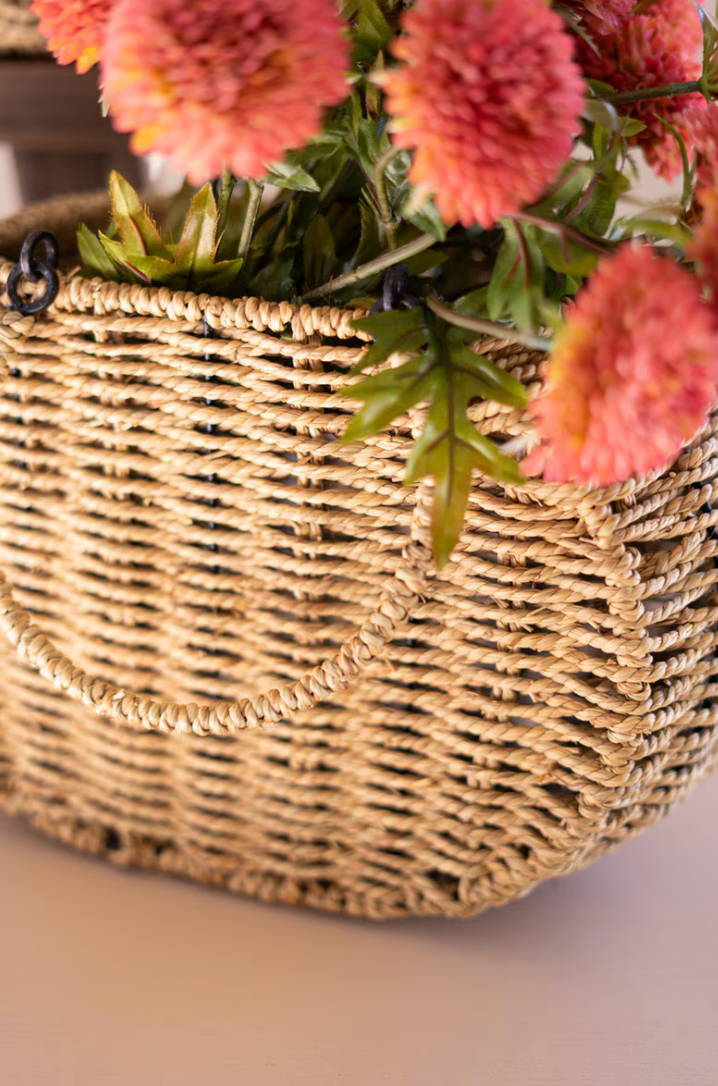 a woven basket up close with pink flowers inside 