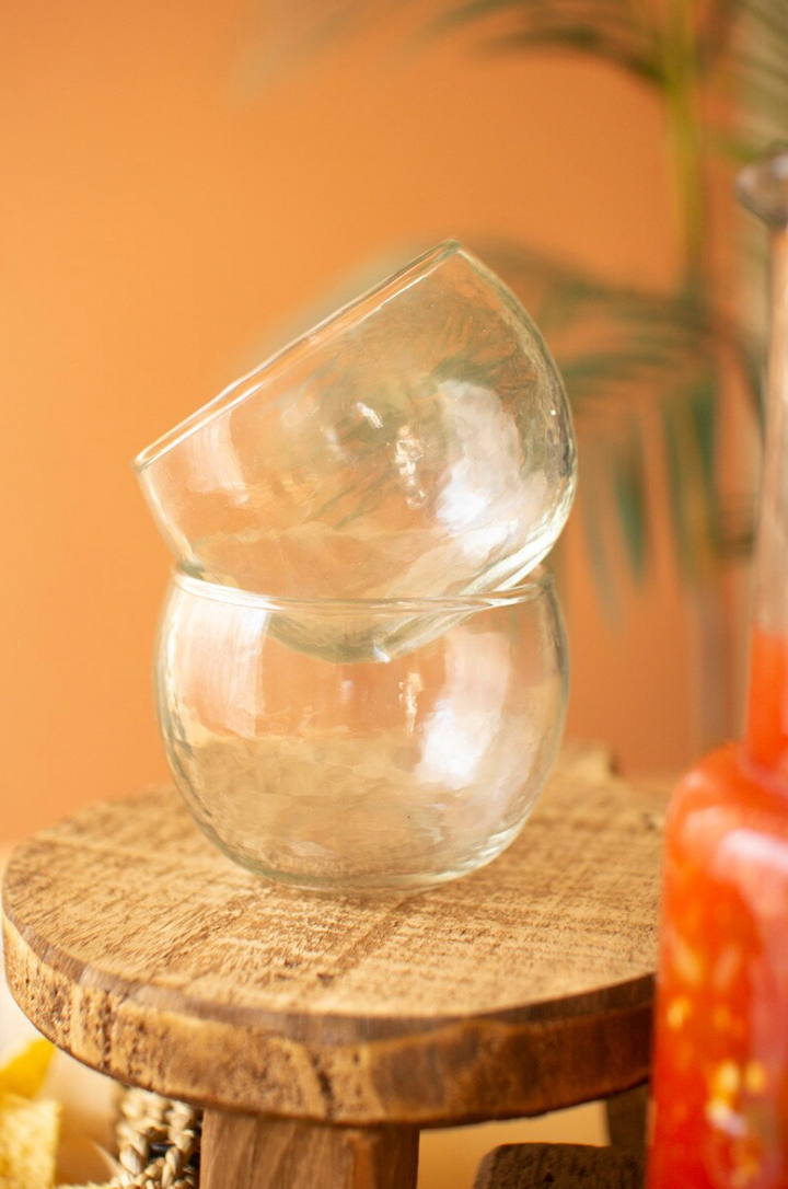 two empty white glass salsa bowls on a wooden stool with an orange background
