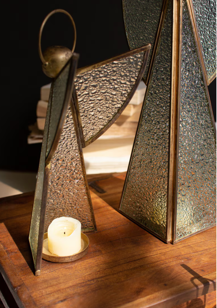 Close-up detail showing textured glass, brass frame, and lit tealight inside