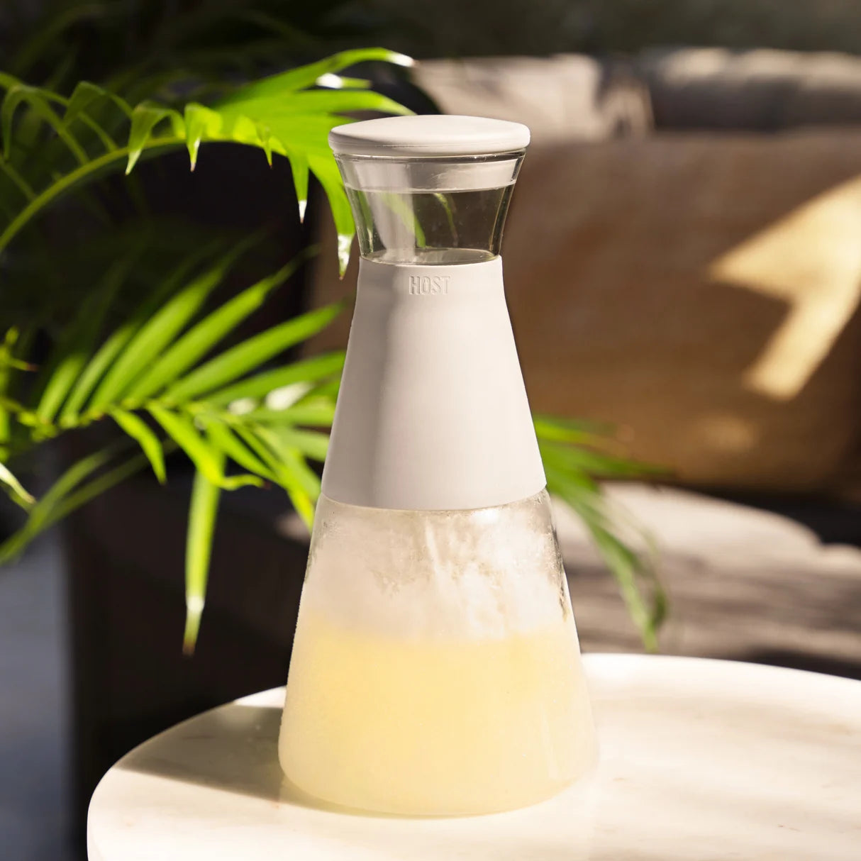 Clear carafe with white base on a table outdoors