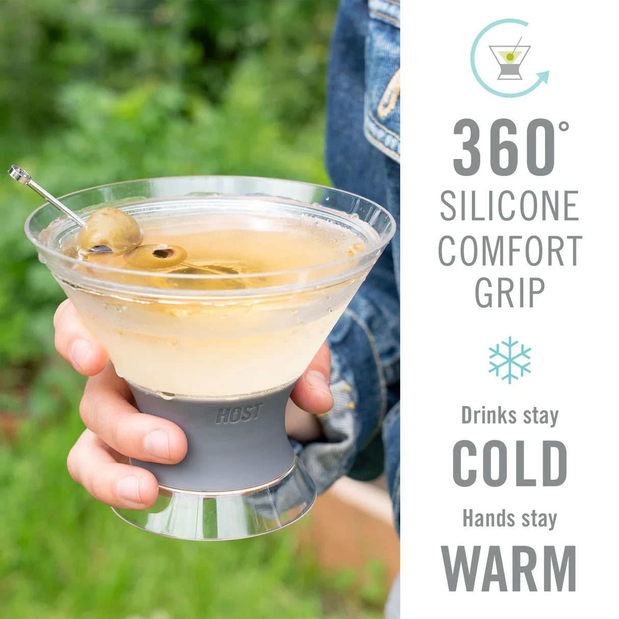 A person holds a clear margarita glass with a gray silicone grip sleeve outdoors. The right side of the image has a white panel with text reading '360° Silicone Comfort Grip', 'Drinks stay COLD', and 'Hands stay WARM', plus a small HOSI logo on the grip.