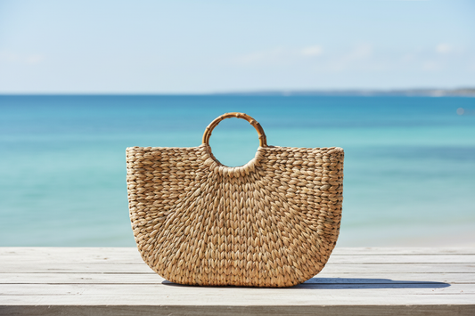 Woven basket bag on table with ocean background, no feathers